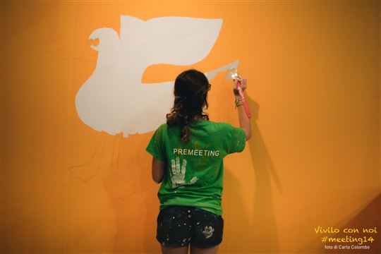 A Rimini Meeting volunteer paints an exhibit wall. Photo by Carlo Colombo via Flickr