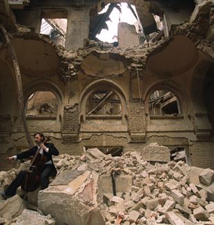 Vedran Smailović playing in the partially destroyed National Library in Sarajevo in 1992. Wikimedia Commons