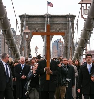 Frank Simmonds carries the cross over the Brooklyn Bridge.