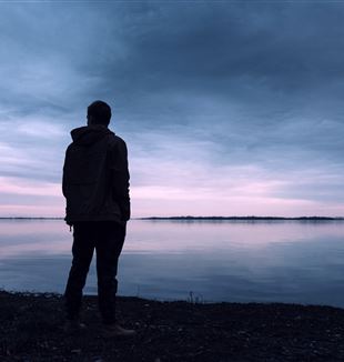Man standing by a lake. CC0