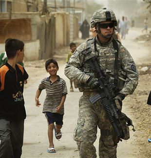 Iraqi Children Gather Around an American Soldier. Wikimedia Commons