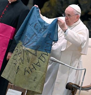 The Pope showing a Ukranian flag sent from Bucha (© Ettore Ferrari/Ansa)